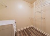 Thumbnail 17 of 49 - A laundry room with a washer and dryer and a shelf. at Integrity Berea Apartments, Berea, Ohio