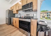 Thumbnail 34 of 39 - A kitchen with wooden cabinets and stainless steel appliances.