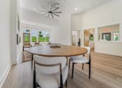 Thumbnail 32 of 39 - A dining room with a round table and chairs.