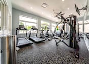 Thumbnail 37 of 39 - A spacious home gym with treadmills, elliptical machines, and other exercise equipment.