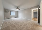 Thumbnail 10 of 32 - A room with a ceiling fan and carpeted floor.