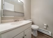 Thumbnail 12 of 32 - A white bathroom with a toilet, sink, and mirror.
