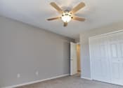 Thumbnail 23 of 36 - Apartment bedroom with carpeting and a ceiling fan light.