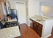Thumbnail 11 of 36 - Townhome galley kitchen with granite countertops and a dishwasher.