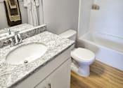 Thumbnail 16 of 36 - Updated bathroom with granite counter and wood flooring.