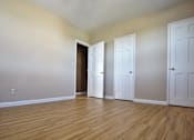 Thumbnail 14 of 35 - Three white doors are in a room  Integrity Realty, Cleveland, OHwith wood floors and beige walls.
