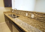 Thumbnail 20 of 36 - Updated apartment kitchen island with granite counters and espresso cabinets.