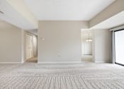 Thumbnail 24 of 42 - A large, empty room with a carpeted floor and a door on the left side.at Atrium in The Village, Beachwood, OH 44122