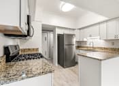 Thumbnail 7 of 42 - A kitchen with granite countertops and stainless steel appliances.at Atrium in The Village, Beachwood, OH 44122