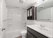 Thumbnail 7 of 15 - White bathroom with tub and espresso-colored cabinets at Integrity Medina Apartments, Medina, OH,  44256