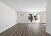 Thumbnail 18 of 32 - Updated Wynwood great room with sliding glass door to balcony and plank flooring.