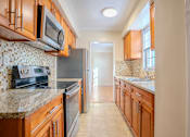 Thumbnail 16 of 35 - A kitchen with wooden cabinets and a tile backsplash Integrity Realty, Cleveland, OH