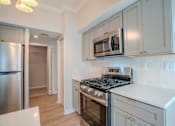 Thumbnail 4 of 42 - A kitchen with a stove, microwave, and refrigerator t Atrium in The Village, Beachwood, OH 44122