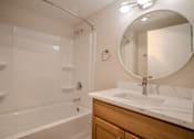 Thumbnail 34 of 42 - A white bathroom with a round mirror and a white sink t Atrium in The Village, Beachwood