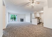 Thumbnail 5 of 46 - Carpeted living area with updated kitchen. at Hunt Club Apartments, Copley, Ohio