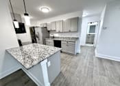 Thumbnail 1 of 14 - A kitchen with a granite countertop and wooden flooring Old Green Place Apartments, Beachwood, OH