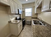 Thumbnail 17 of 35 - An updated galley  kitchen with granite countertops and a window Integrity Realty, Cleveland