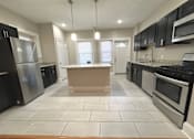 Thumbnail 2 of 37 - A kitchen with black appliances and white tiled floors at Integrity Cleveland Heights Apartments, Apartments, Cleveland Heights, OH