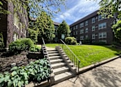 Thumbnail 7 of 37 - A set of stairs leads up to a grassy area in front of a brick building. at Integrity Cleveland Heights Apartments, Cleveland Heights, Ohio