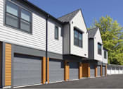 Thumbnail 4 of 29 - A modern house with a grey and brown exterior and a black roof.