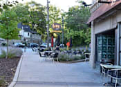 Thumbnail 8 of 29 - A restaurant named Luna is located in a green area with tables and chairs outside.