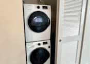 Thumbnail 12 of 29 - Two washing machines are stacked in a cabinet.