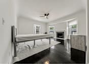 Thumbnail 17 of 29 - A spacious bedroom with a large bed and a fireplace.