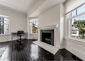 Thumbnail 18 of 29 - A black and white room with a fireplace and a chair.