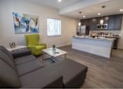 Thumbnail 1 of 29 - A modern living room with a grey sofa and a green armchair.