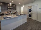 Thumbnail 2 of 29 - A modern kitchen with dark cabinets and stainless steel appliances.