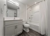 Thumbnail 21 of 29 - A white bathroom with a toilet, sink, and bathtub.