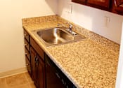 Thumbnail 18 of 35 - A kitchen with a granite counter top and wooden cabinets Integrity Realty, Cleveland, OH