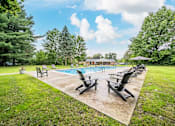 Thumbnail 35 of 35 - A pool surrounded by lawn chairs and trees.