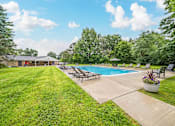 Thumbnail 32 of 35 - A pool surrounded by lawn chairs and trees.