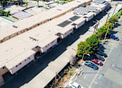 Thumbnail 18 of 18 - Aerial drone photo of Woodbridge Park Apartments, showing white solar roofs and Solar Panels.
