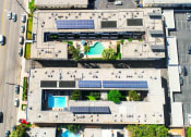 Thumbnail 28 of 28 - Aerial drone image of Sherman Oaks Gardens, showing solar panels and energy-efficient white roof.