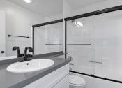 Thumbnail 11 of 19 - White bathroom with modern fixtures, shower, and tub.