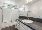 Thumbnail 6 of 15 - Modern styled bathroom with shower and tub.
