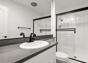 Thumbnail 9 of 25 - Modern styled bathroom with shower and tub.