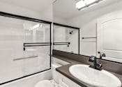 Thumbnail 9 of 15 - Modern styled bathroom with shower and tub.