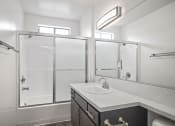 Thumbnail 15 of 28 - Modern styled bathroom with shower and tub.