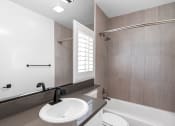 Thumbnail 11 of 22 - Modern styled bathroom with shower and tub.