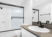 Thumbnail 11 of 23 - Modern styled bathroom with shower and tub.