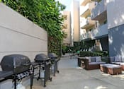 Thumbnail 21 of 31 - Courtyard view of community seating area next to barbecues.