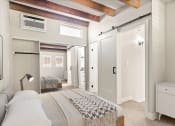 Thumbnail 15 of 25 - Carpeted bedroom with ceiling fan and access to private bathroom.