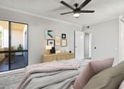 Thumbnail 3 of 21 - Carpeted bedroom with ceiling fan and natural light from adjacent patio.