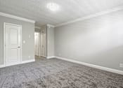 Thumbnail 7 of 14 - Carpeted bedroom with crown moulding and private bathroom.