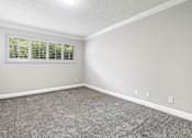 Thumbnail 8 of 14 - Carpeted bedroom with crown moulding and large exterior windows.