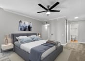 Thumbnail 13 of 21 - Carpeted bedroom with ceiling fan and private bathroom.