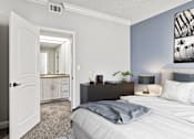 Thumbnail 8 of 24 - Carpeted bedroom with private bathroom.